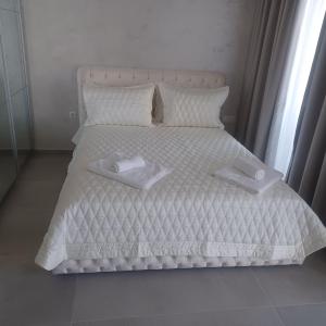 圣君士坦丁和海伦那Romantic Holiday Studio的一张白色的床,上面有两条白色毛巾