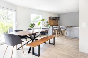 TreyvauxChambre Lumineuse Dans Une Maison Moderne的厨房以及带木桌和椅子的用餐室。