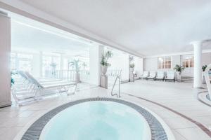 奥伯古格尔Gourmet & Wine Hotel Austria - 4 Sterne superior的一个带门廊的房间的大型游泳池