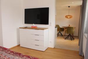 萨尔茨堡Junker's Apartments的一间客厅,客厅内配有白色梳妆台上的电视