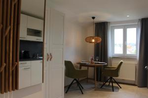 萨尔茨堡Junker's Apartments的厨房以及带桌子和窗户的用餐室。
