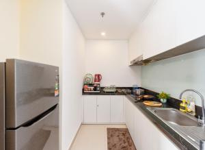 芽庄S Lux Apartment Virgo的白色的厨房配有水槽和冰箱