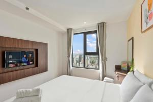 芽庄S Lux Apartment Virgo的卧室配有白色的床和电视