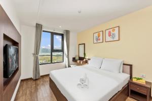芽庄S Lux Apartment Virgo的卧室设有一张白色大床和一扇窗户。