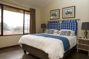 察嫩Featherbrook Cottage的一间卧室配有一张带蓝白色床单的大床