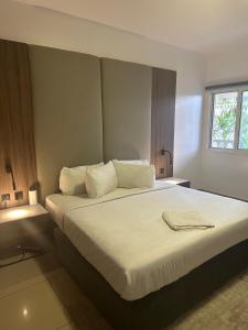 拉各斯Guided Hospitality - Luxury Accommodations的一间卧室配有一张带白色床单的大床