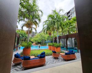 华欣La Habana HuaHin by ABCD的一个带游泳池、椅子和棕榈树的度假村