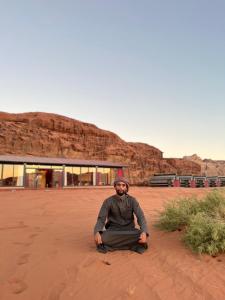 瓦迪拉姆Wadi Rum Golden Valley的坐在沙漠地面上的人