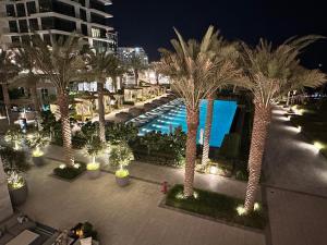 麦纳麦Address Beach Resort Residence的享有棕榈树和游泳池的度假村的顶部景致
