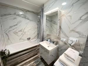 布拉索夫Deluxe Cozy Apartments - Coresi Mall #Brasov的白色的浴室设有水槽和浴缸。