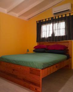 Santa CruzHopi Cadushi Apartment的一间卧室配有一张木床和窗户