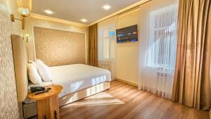 希瓦Hotel Bankir Khiva的一间卧室配有一张床、一张桌子和一个窗户。