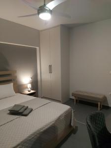 特里卡拉Square Apartments的一间卧室配有一张床和吊扇