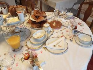 圣莱奥纳尔德诺布拉MAISON GAY LUSSAC St LEONARD DE NOBLAT的一张桌子,上面有白色的桌布,上面有食物