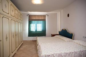蒙特法尔科绿色村庄农家乐的一间卧室设有一张床和一个绿色的窗户