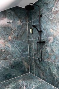 珀丽Hotel Wehra的带淋浴的浴室(带石墙)