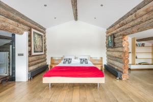 夏蒙尼-勃朗峰Spectacular Chalet with 5 ensuite bedrooms and sauna的一间卧室配有一张带红色毯子的床