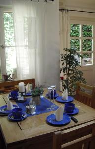 爱尔福特罗伊斯膳食公寓 - 加尼酒店的一张带蓝色盘子和餐巾的木桌