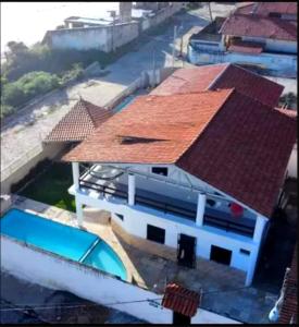 考卡亚Pousada e Hostel Lua de Tomate的一座红色屋顶的房子和一个游泳池