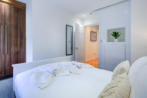 布伦特伍德Spacious One Bedroom Apartment in The Heart Of Brentwood的卧室配有白色床和毛巾