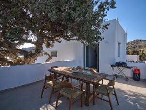 莫罗斯帕罗Private Luxury Scarlet beachfront villa, Molos, Paros的天井上树木的木桌和椅子