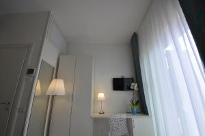 切萨雷奥港Di Ma B&B的一间设有窗户和灯的白色墙壁客房