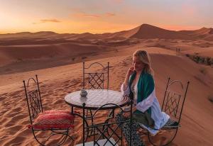 梅尔祖卡Nomada Domes的坐在沙漠桌子上的女人