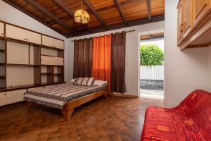 PaeaApetahi Lodge的一间卧室配有一张床和一张红色的沙发