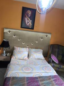 哈科特港Eunique Residence的卧室内的一张床铺,墙上挂着一幅画