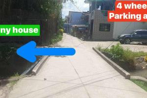 DaetCozy TinyHouse near SM City Daet的蓝色箭头指向有房子的车道