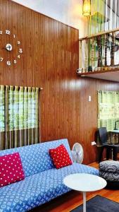 DaetCozy TinyHouse near SM City Daet的客厅配有蓝色沙发和红色枕头