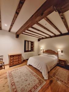桑提亚纳德玛APARTAMENTOS PALACION DE SANTILLANA的一间卧室设有一张大床,铺有木地板
