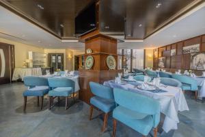 阿尔及尔Lalla Doudja Hotel的一间配备有桌子和蓝色椅子的用餐室