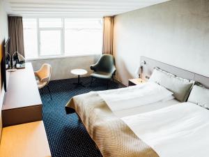 托尔斯港佛洛雅酒店的配有一张床和一把椅子的酒店客房