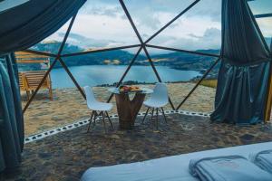 安达韦拉斯Glamping Nuna Experience的配有桌椅的帐篷,享有湖景