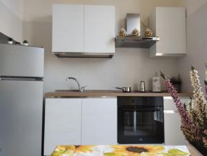库尼奥La Villetta a Cuneo的厨房配有白色橱柜和黑烤箱。
