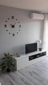 埃勒凡达尔Apartamento acogedor的客厅配有电视和墙上的时钟