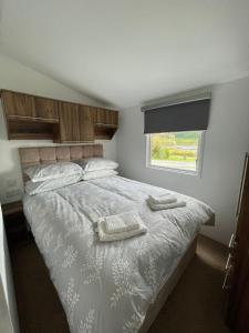 波特里STORR (caravan skye holidays)的一间卧室配有一张床,上面有两条毛巾