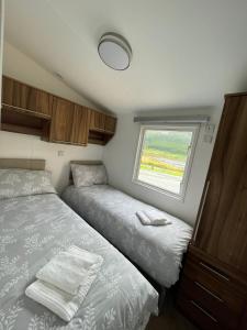 波特里Caravan Skye Holidays的一间小卧室,配有两张床和窗户