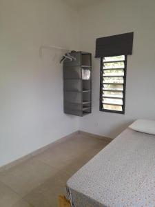 利伯维尔Villa en résidence à Malibé Libreville的一间卧室设有一张床和一个窗口