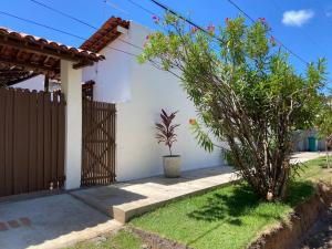 帕里普埃拉Casa Paraiso de Sonho Verde的一座带栅栏和植物的白色房子