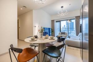 迪拜DownTown, Dubai Burj Royale 2 BDR Apartment Full Burj - Khalifa view的厨房以及带桌椅的起居室。