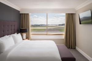 希灵登伦敦希思罗机场万丽酒店的一间卧室设有一张大床和一个大窗户