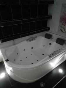 基布多Hotel Emalú M&C的浴室设有白色浴缸,配有灯光