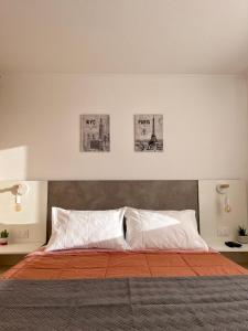卡尔德拉Caldera Apartment的卧室配有一张墙上三幅照片的床
