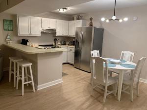 默特尔比奇Sealoft 4 Townhouse的厨房配有桌椅和冰箱。