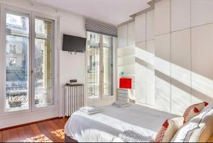 巴黎Chic Parisian Flat的客房设有1张床、1台电视和窗户。