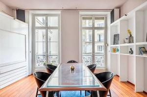 巴黎Chic Parisian Flat的一间设有玻璃桌和椅子的用餐室