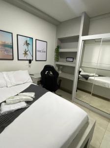 乌贝兰迪亚Flats Uberlândia的卧室配有一张白色大床和镜子