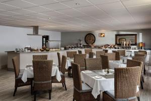 鲸湾港Protea Hotel by Marriott Walvis Bay Indongo的餐厅设有白色的桌椅和柜台